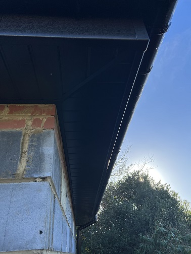 Black woodgrain soffit and fascia with black round guttering
