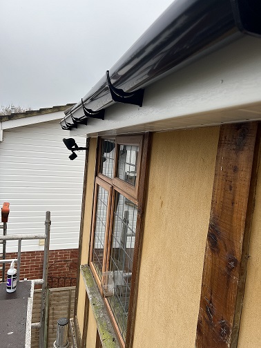 White ash soffit and fascia with black round guttering